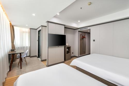 Una habitación de hotel con dos camas y un televisor de pantalla plana. en Xiangshang Hotel&Canton Fair Shuttle Bus, en Guangzhou