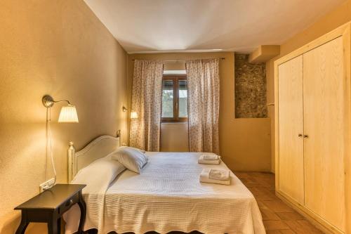 a small bedroom with a bed and a window at Mas la Ginesta in Borrassá