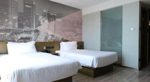 Postel nebo postele na pokoji v ubytování ibis Styles Wuhan Optics Valley Square Hotel