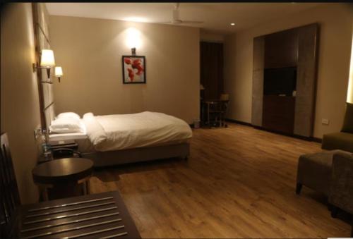 a hotel room with a bed and a living room at Hotel Golden Palm in Gurdāspur
