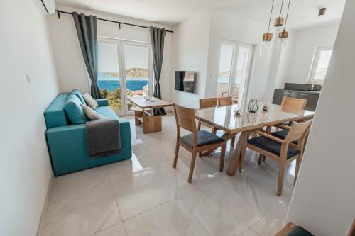 Una sala de estar con un sofá azul y una mesa. en Elia apartments, en Ražanj