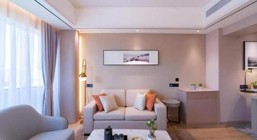 a living room with a couch and a chair at GreenTree Eastern Dali Railway Station Hotel in Dali