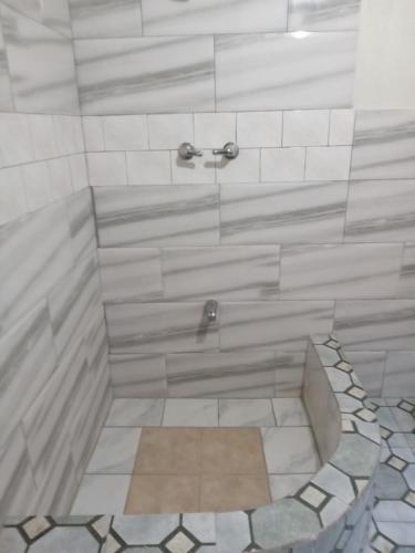 a bathroom with a shower with a tile floor at Apartments 145 in Georgetown