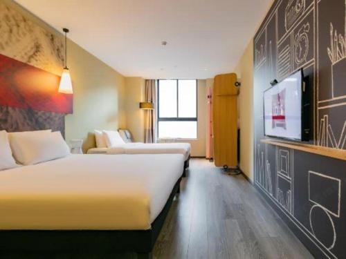 a hotel room with two beds and a flat screen tv at ibis xian North Second Ring Weiyang Rd Hotel in Xi'an