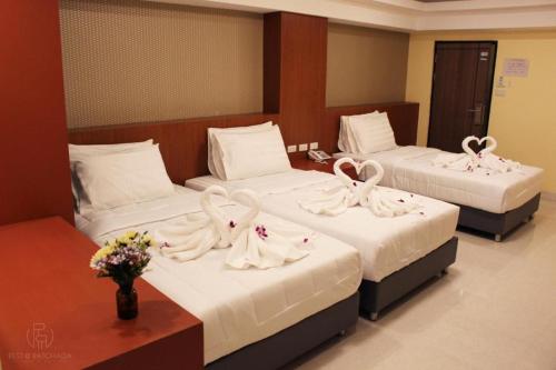 two beds in a hotel room with towels on them at Rest@Ratchada hotel in Bangkok