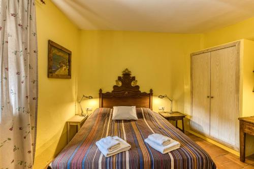 a bedroom with a bed with two towels on it at Mas la Ginesta in Borrassá