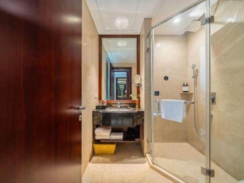 a bathroom with a shower and a sink and a mirror at Huading International Hotel in Hangzhou