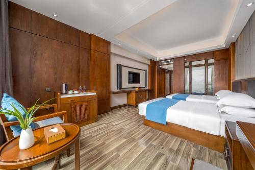 a bedroom with a bed and a desk and a table at Lijiang Riverside Luxury Hotel, Guilin in Guilin