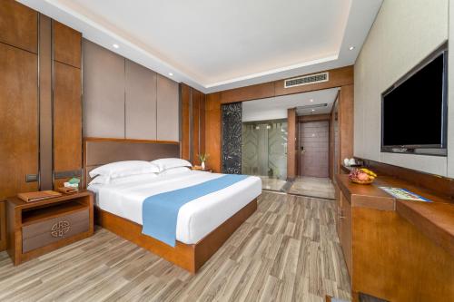 a bedroom with a large bed and a flat screen tv at Lijiang Riverside Luxury Hotel, Guilin in Guilin