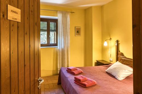 a bedroom with a bed with two towels on it at Mas la Ginesta in Borrassá