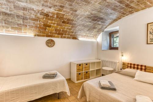 a bedroom with two beds and a brick wall at Mas la Ginesta in Borrassá