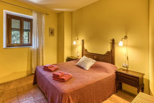a bedroom with a bed with two towels on it at Mas la Ginesta in Borrassá