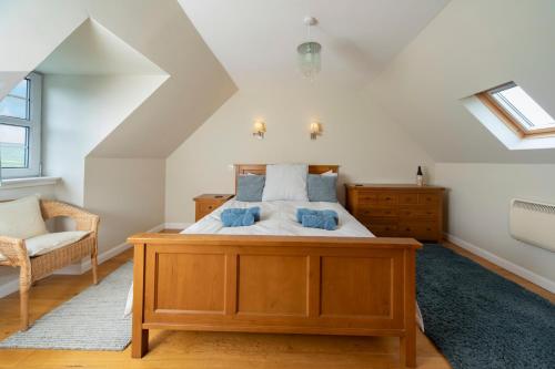 una camera da letto con un letto grande e una sedia di Charming Isle of Skye Holiday Cottage, Glendale a Glendale