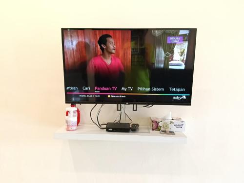 a flat screen tv sitting on a shelf at Azzahra Homestay in Permatang Pauh