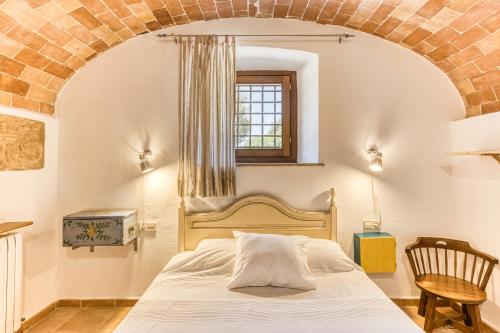a bedroom with a bed with a brick wall at Mas la Ginesta in Borrassá