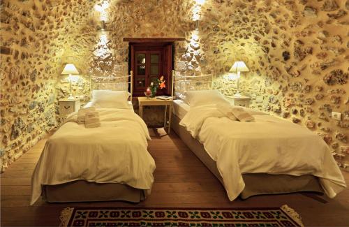 a bedroom with two beds in a room with wallpaper at Archontiko Chioti in Leonidion
