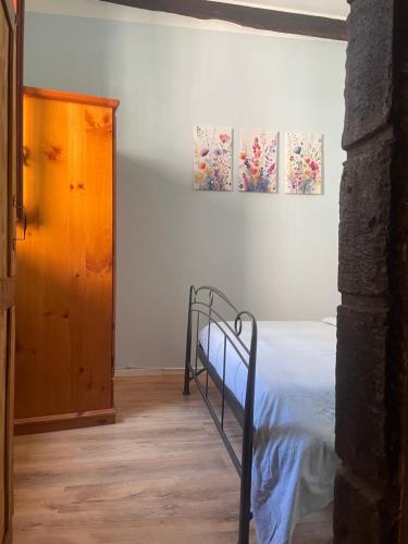 a bedroom with a bed and two paintings on the wall at Colonna House in Genazzano