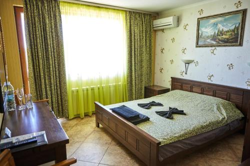 1 dormitorio con cama, mesa y ventana en Villa Katalina, en Varna