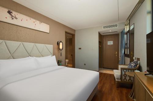 Postel nebo postele na pokoji v ubytování ARULA Youngor Central Hotel-Suzhou Guanqian St