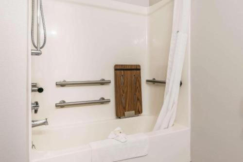 a bathroom with a bath tub with a shower curtain at Suburban Studios Mason Hwy 42 in Mason