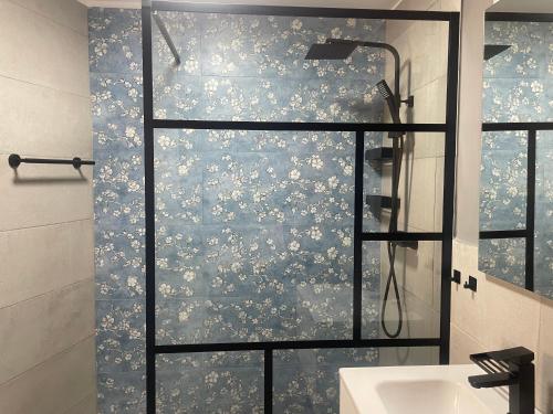 a shower with a glass door next to a sink at Colonna House in Genazzano