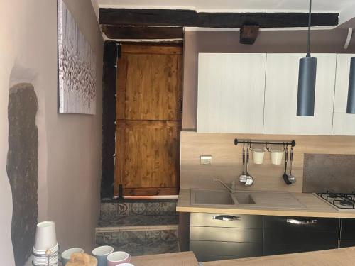 a kitchen with white and wooden cabinets and a sink at Colonna House in Genazzano