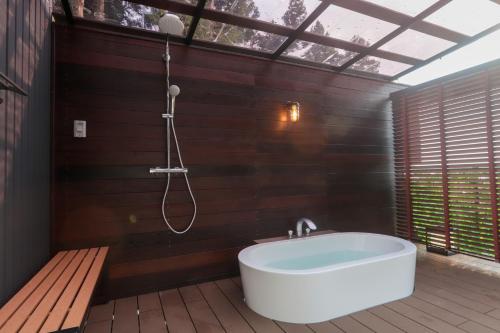 a bathroom with a bath tub and a shower at Wellリゾート富士 in Gotemba