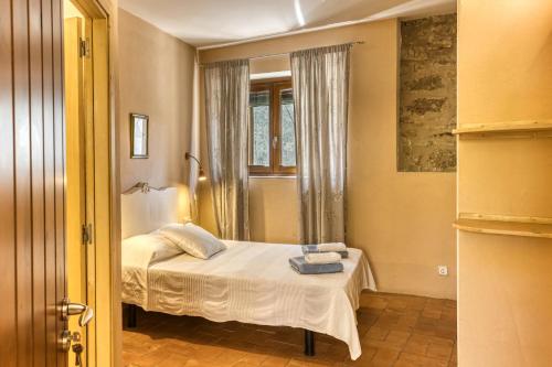 a small bedroom with a bed and a window at Mas la Ginesta in Borrassá