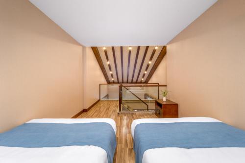 two beds in a room with a window and a room with two beds at Lijiang Riverside Luxury Hotel, Guilin in Guilin