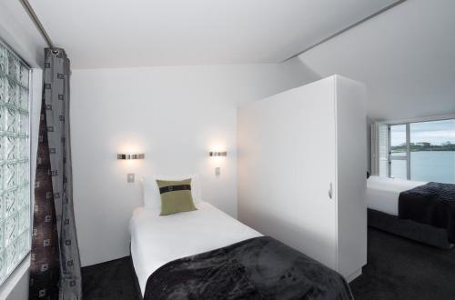 a small bedroom with a bed and a window at The Tauranga on the Waterfront in Tauranga