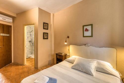 a bedroom with a white bed and a bathroom at Mas la Ginesta in Borrassá