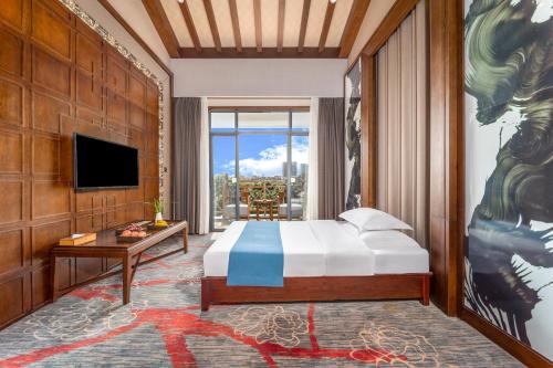 a bedroom with a bed and a large window at Lijiang Riverside Luxury Hotel, Guilin in Guilin