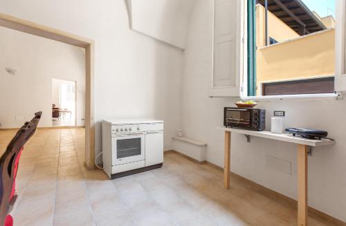 a kitchen with a white stove and a microwave at Il profumo dei Colori by BarbarHouse in San Cesario di Lecce