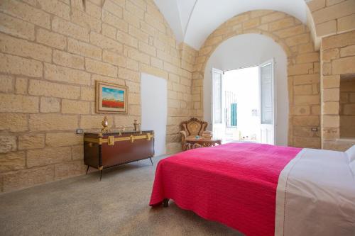 a bedroom with a large bed and a brick wall at Il profumo dei Colori by BarbarHouse in San Cesario di Lecce
