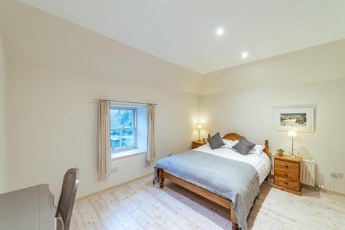 a white bedroom with a bed and a window at Penninghame Estate - Bruce Apartment in Challoch