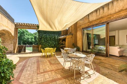 a patio with a table and chairs and a tree at Mas la Ginesta in Borrassá