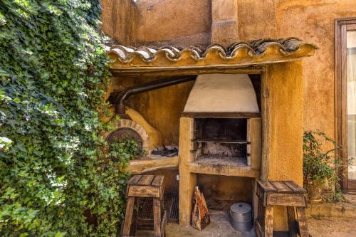 an old kitchen with two stools in front of a wall at Mas la Ginesta in Borrassá