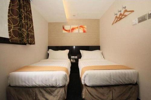 two beds in a hotel room with at Noble Park Hotel in Hong Kong