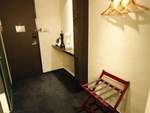 a red chair sitting in a hallway next to a door at Noble Park Hotel in Hong Kong