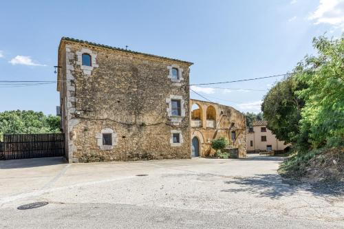 an old stone building with a blue door at Mas la Ginesta in Borrassá