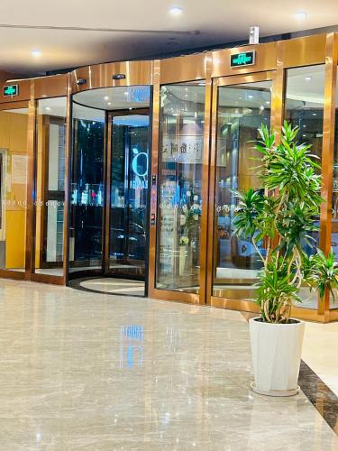 a building with glass doors and a potted plant at Orange Hotel Beijing Yizhuang Bridge Subway Station in Beijing