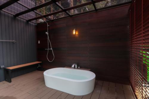 a bathroom with a bath tub and a shower at Wellリゾート富士 in Gotemba