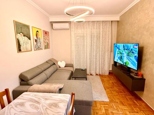 a living room with a couch and a flat screen tv at Cozy 2 Bedroom Condo by Waterfront & Metro in Thessaloniki