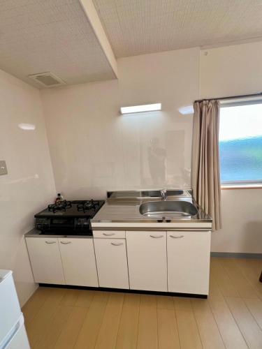 a kitchen with a sink and a stove at スマートハウスみづほ in Hitoyoshi