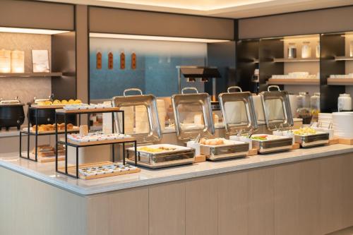 a buffet line with different types of food on display at Ji Hotel Beijing Wudaokou University of Mining and Technology in Beijing