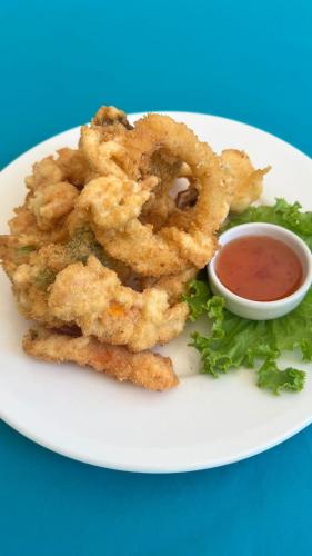 a plate of fried onion rings with a dipping sauce at Baan Kiao in Haad Yao