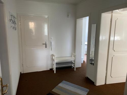 a room with a white door and a bench in it at Messewohnung Düsseldorf in Düsseldorf