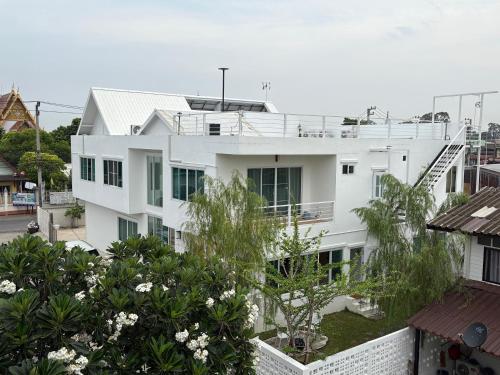 a white building with trees in front of it at Na KlongMuang B2 in Phra Nakhon Si Ayutthaya