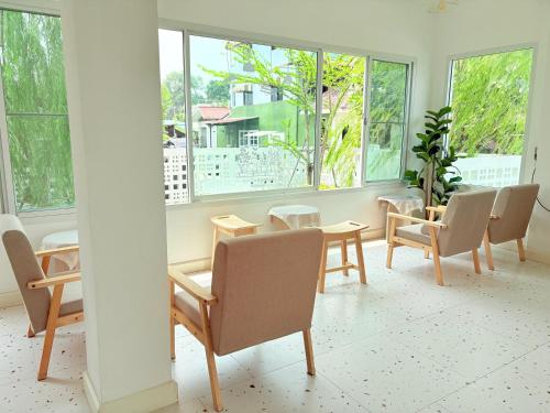 a room with a table and chairs and windows at Na KlongMuang B2 in Phra Nakhon Si Ayutthaya