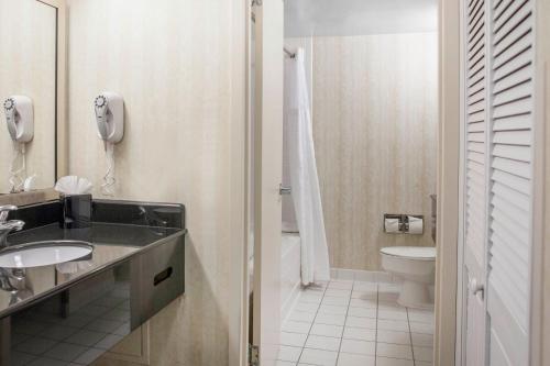 La salle de bains est pourvue d'un lavabo, de toilettes et d'un téléphone. dans l'établissement Comfort Inn Pentagon City, à Arlington